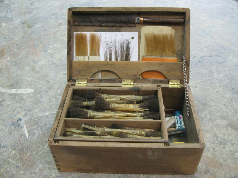 Una scatola di strumenti, tra cui un coltello da doratore, pennellessa da doratore, pennelli supportati...